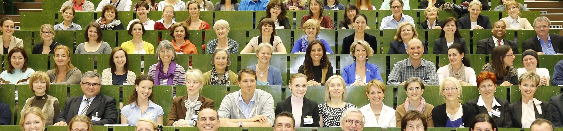 Group photo in a lecture hall with green chairs