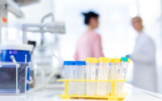 Pipettes in a laboratory in front of two female researchers in the background