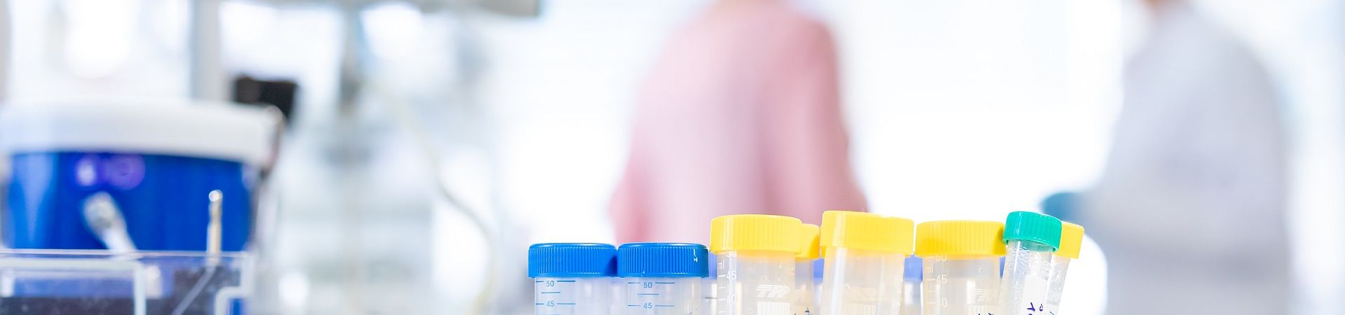 Pipettes in a laboratory in front of two female researchers in the background