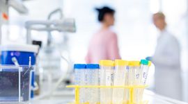 Laboratory situation with pipettes in the foreground and two female researchers in the background.