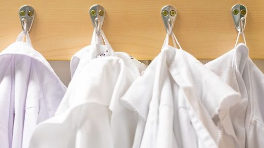 White working coats hanging on a wardrobe.