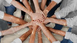 People in Circle holding their Hands Together in the middle, view from the top